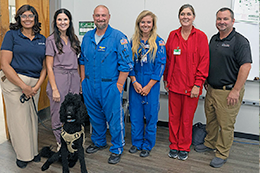 Gathering after the presentation are from left, Kawanna McCormick, health systems operations manager; Tara Coody, MCC Associate Degree Nursing Program instructor; Ben White, critical care paramedic; Ally Westrope, flight nurse; Don Moore, base supervisor for Meridian and critical care medic; and Melanie Pinter, MCC Associate Degree Nursing Program instructor. Seated is Aero, GMR therapy dog.  