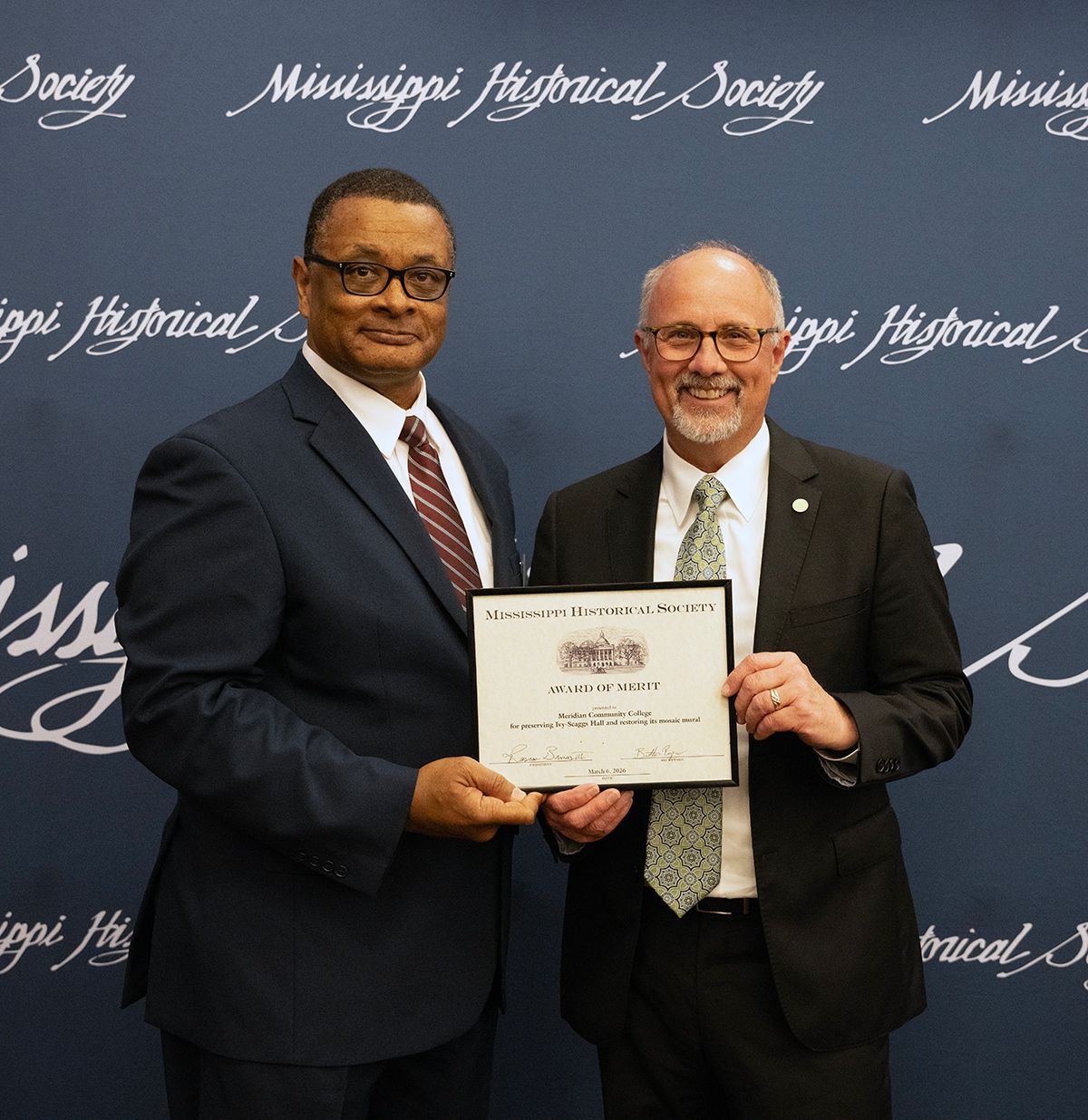 Mississippi Historical Society President Roscoe Barnes III, left, presents MCC President Dr. Tom Huebner with the Society’s Award of Merit for the College’s efforts to restore Ivy-Scaggs Hall’s mosaics. 
