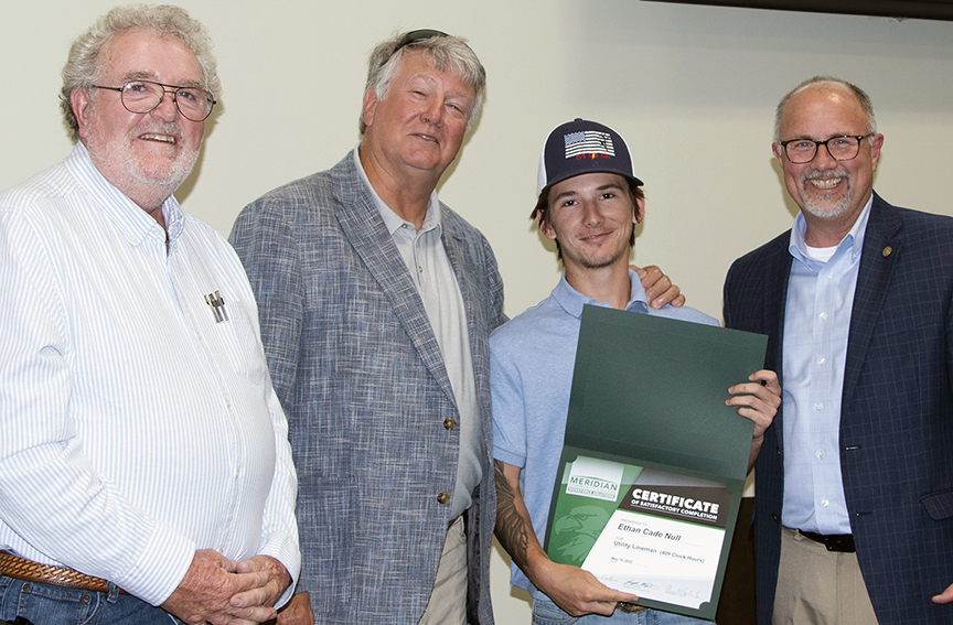 Completer Cade Null, third from left, is congratulated by Utility Lineman Program instructors Wally Collins, left, and Kim Culpepper, and MCC President Dr. Thomas Huebner, right.