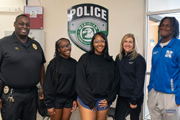 Zy’Keria Ford, Carson Willis, and Courtney Smith pose for a photo with an MCC police officer. 
