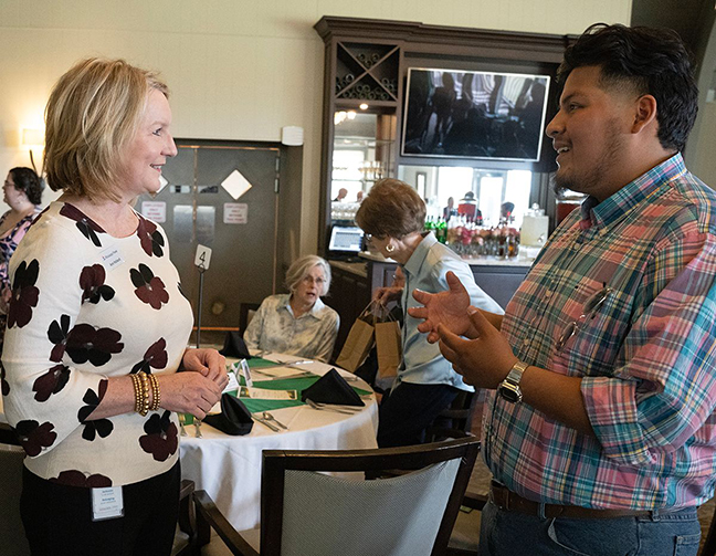 Ann Holland, community development representative with Mississippi Power Co., left, talks with MCC student Pedro Gonzalez during the MCC Foundation Donor Appreciation Luncheon. 