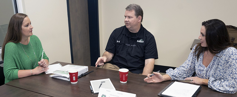 Brandy Hill, left, Tony Boutwell, and An Howard Hill plan a solution for an human resources issue during an exercise at the latest ELC session. 