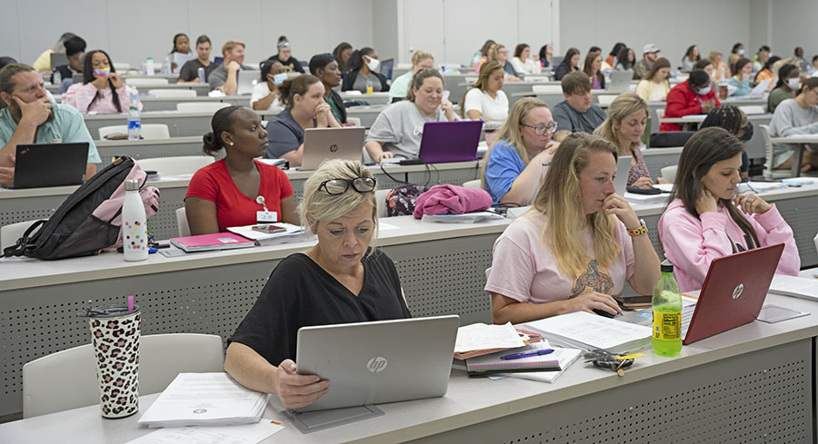 Students in the Associate Degree Nursing Program listen and take notes during an orientation session. 