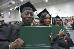 Graduates pose with their diplomas.