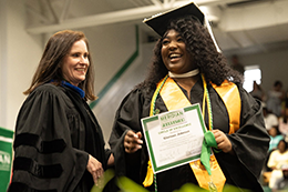Glorius Johnson, a Cosmetology Program graduate from Meridian, receives he Circle of Excellence award on stage.