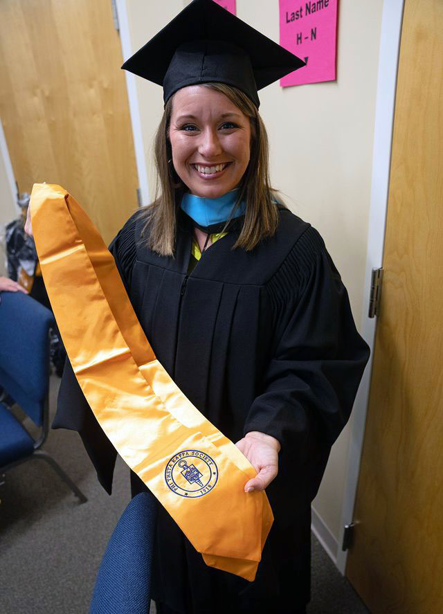 Phyllis Holladay shows one of the PTK graduation stoles. 