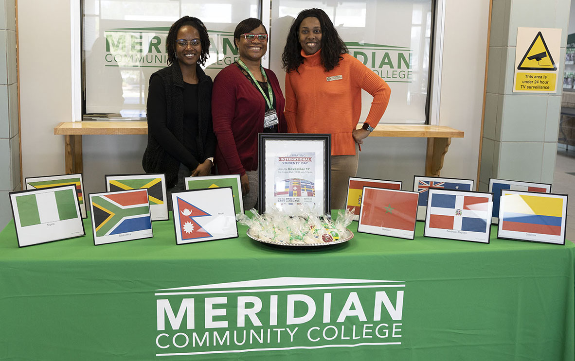 Welcoming students to the International Student Day display are Ashley Tanksley, left, Marlo Turner and Nedra Bradley. 