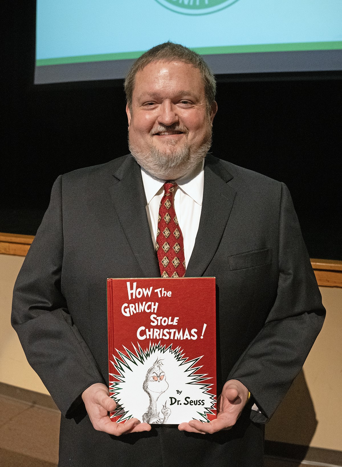 Jade Parkes with his favorite Dr. Seuss book, How the Grinch Stole Christmas! Parkes' Humanities Instructor of the Year lecture at Meridian Community College delved into Dr. Seuss's political cartoons before the artist became known for his children's books.