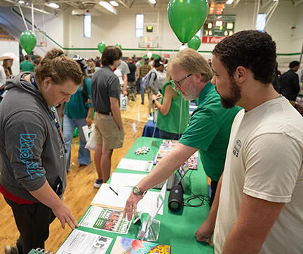 Jesse Mixon, right, along with Mitch Brantley, center, talks to a high school student during the College and Career Fair hosted by MCC. Last year, Mixon was an attendee at the fair. 