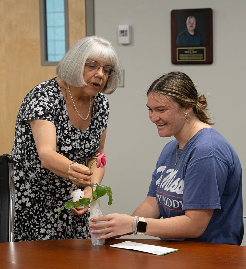 During the Mark Gunn Memorial Scholarship presentation, Sherry Gunn presents recipient Lanie Crawford with an essay and flowers. Sherry Gunn is the wife of the late Mark Gunn, an MCC history instructor. 