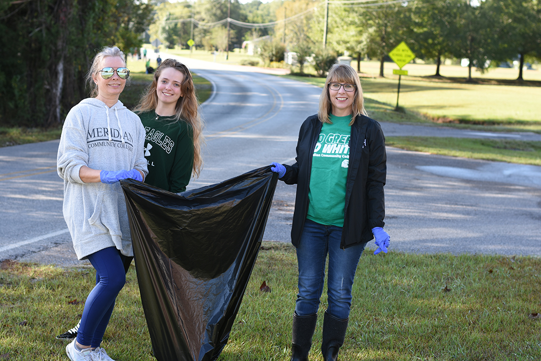 Cyndy Bratu, Bethany Bratu, and Amanda Bratu volunteer by picking up trash. 