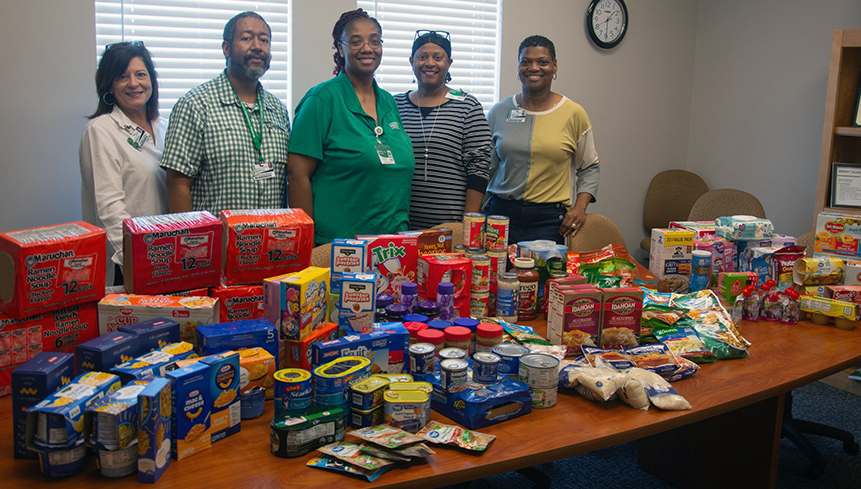 Adult Education Department staffers with their donations. The department was one of many participating in the drive to restock the College’s food pantry. 