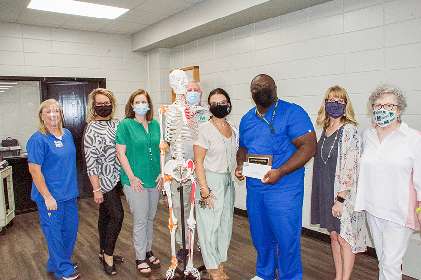 Joining in congratulating Dr. Tommy Winston, fifth from left, are Jenny Bryan, academic coordinator for clinical education; Kristi Williamson, circulation/catalog librarian and co-PTK advisor; Dr. Lara Collum, associate vice president for nursing and healthcare education; Leia Hill, vice president for institutional advancement and executive director for the MCC Foundation; Amanda Bratu, administrative assistant for the MCC Foundation and Marmion Francis, Lifetime Quest co-coordinator.