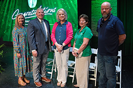 MCC retirees pose for a photo on the stage in McCain Theater.