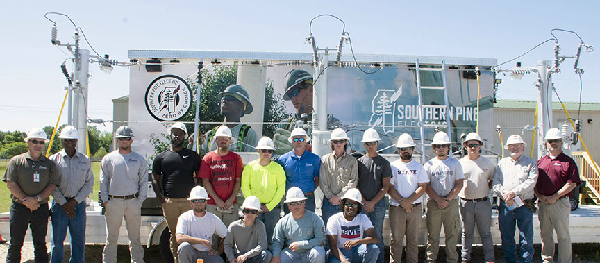 Southern Pine Electric officials and MCC Lineman Program students gather after safety talk.
