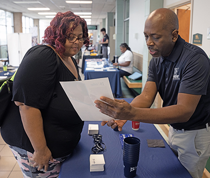 MCC student Teresa Terrell looks over information material with Keith Riley, an academic evaluator with Jackson State University. 