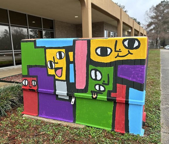 Vibrant colors are wrapped around one of the completed above-ground utility box art designs. 