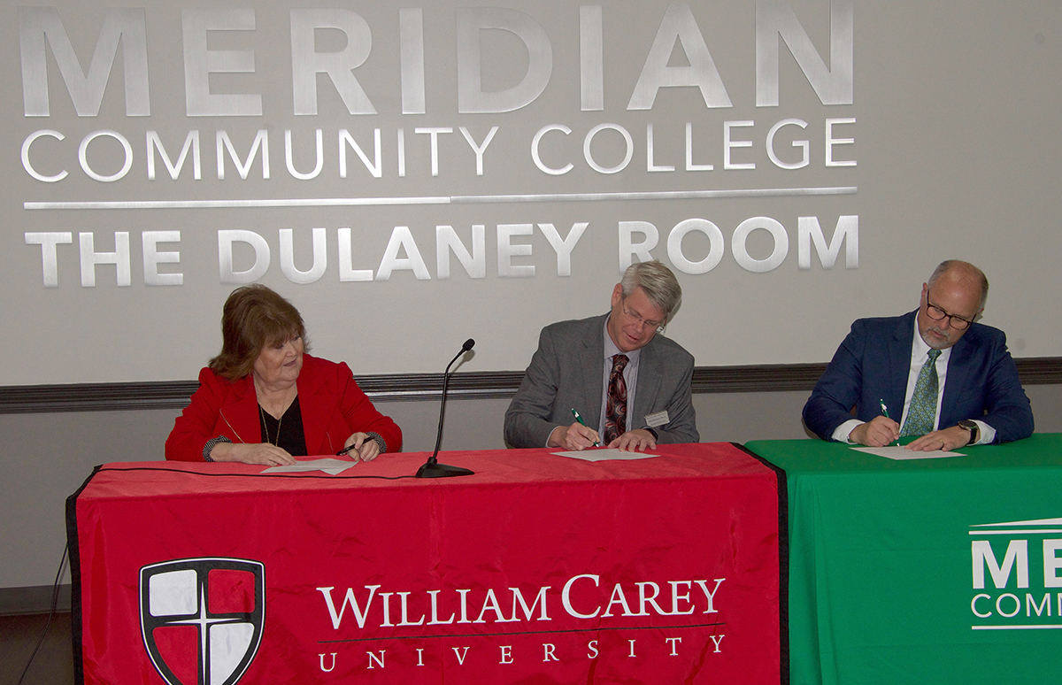 Dr. Janet K. Williams, associate vice president for health programs, and Dr. Ben Burnett, executive vice president, both of William Carey University, and Dr. Thomas Huebner, president of Meridian Community College, sign a memo of understanding agreement on the MCC campus. The signing marked the second time the educational institutions have joined in an MOU. 